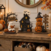 Three glowing Halloween figurines on a rustic tabletop with autumn décor