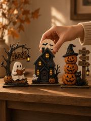Hand arranging vintage Halloween tabletop figurines on a warm wooden mantel